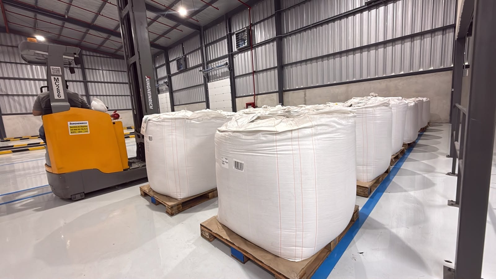 Palletized big bags stored in rows at Terminal Logístico Durán with a reach truck working alongside